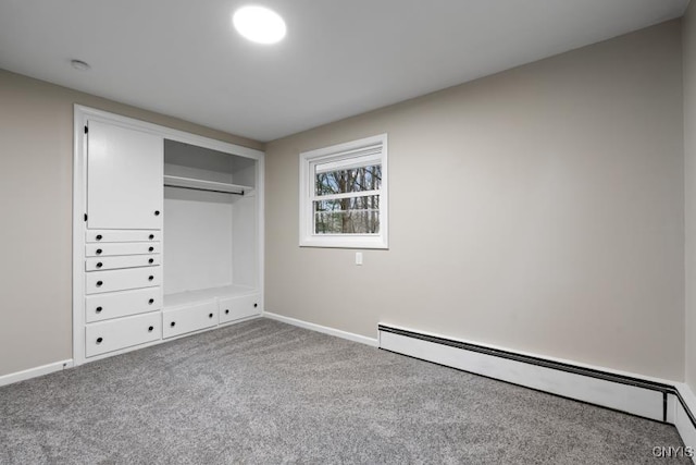 unfurnished bedroom featuring a closet, baseboard heating, and carpet