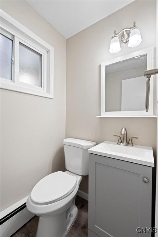 bathroom featuring toilet, wood-type flooring, vanity, and baseboard heating