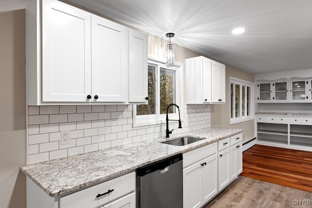 kitchen with dishwasher, light hardwood / wood-style floors, sink, white cabinetry, and decorative light fixtures