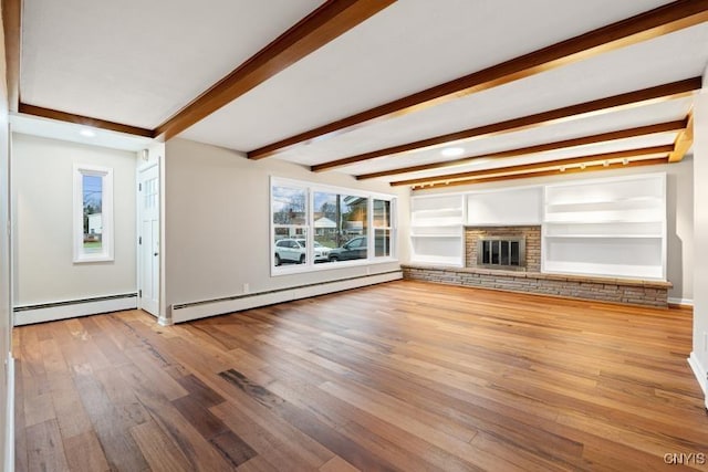 unfurnished living room featuring baseboard heating, built in features, hardwood / wood-style flooring, and beamed ceiling