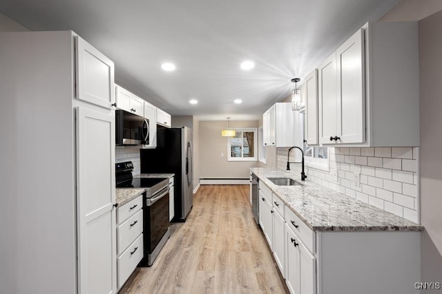 kitchen with appliances with stainless steel finishes, white cabinets, decorative light fixtures, and sink