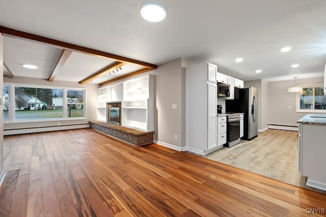 unfurnished living room featuring a baseboard radiator, a wealth of natural light, light hardwood / wood-style floors, and beam ceiling