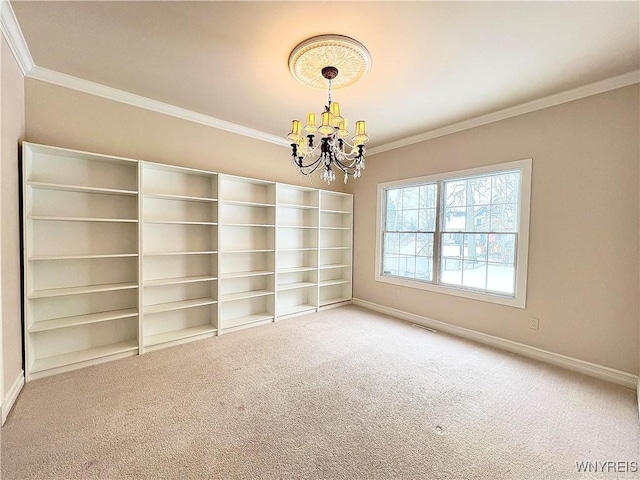 empty room with a notable chandelier, crown molding, and carpet