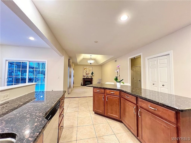 kitchen with light tile patterned flooring, a center island, dishwasher, and dark stone counters