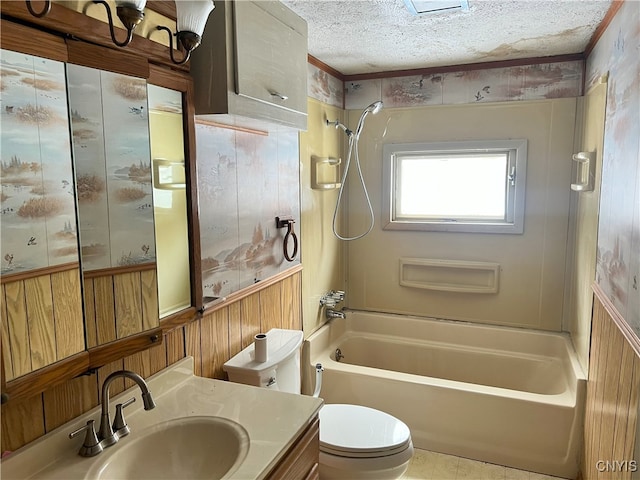 full bathroom featuring toilet, wood walls, a textured ceiling, shower / washtub combination, and vanity