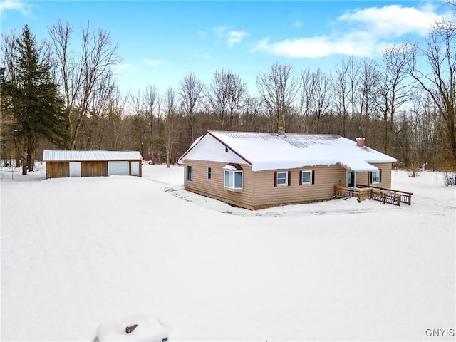 snow covered back of property with a garage