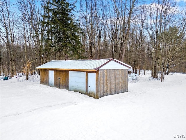 snow covered structure with a garage