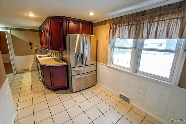 kitchen with backsplash, stainless steel fridge, light tile patterned floors, and sink