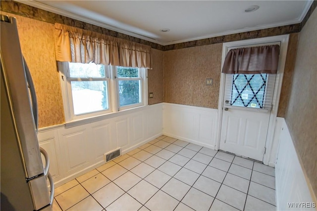 interior space with light tile patterned floors and crown molding