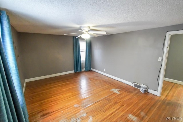 empty room with a textured ceiling, ceiling fan, and hardwood / wood-style floors