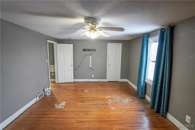 spare room with hardwood / wood-style flooring, a textured ceiling, and ceiling fan