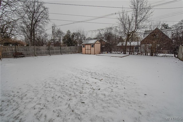 yard covered in snow featuring a storage unit