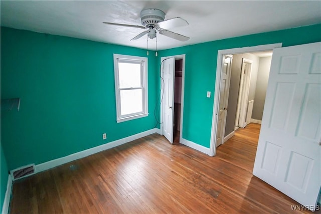 unfurnished bedroom featuring a closet, ceiling fan, and dark wood-type flooring