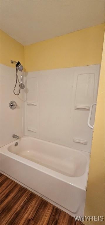 bathroom with hardwood / wood-style flooring and shower / bathtub combination