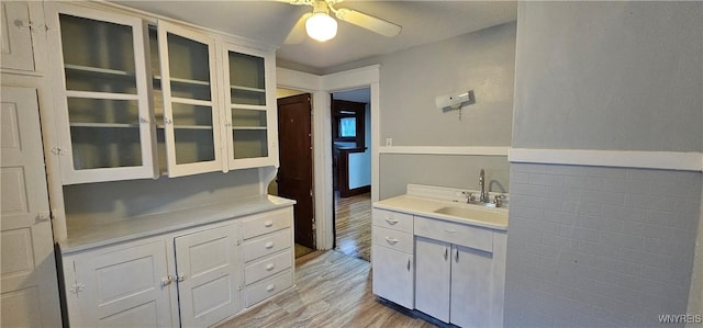 bathroom with hardwood / wood-style flooring, ceiling fan, and sink