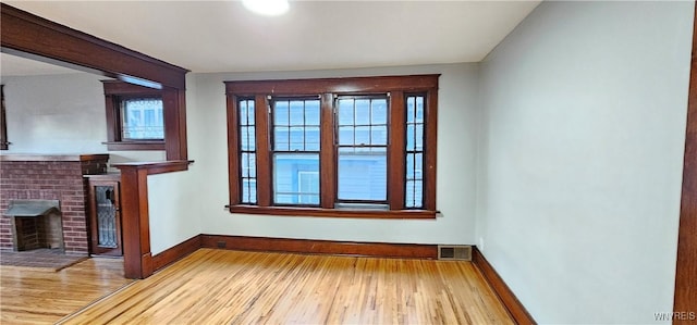 unfurnished living room with a fireplace and wood-type flooring