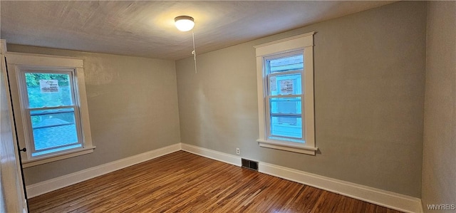 unfurnished room featuring hardwood / wood-style flooring and a healthy amount of sunlight