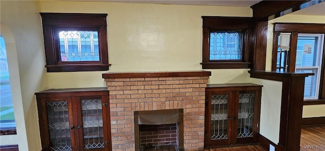 room details featuring a brick fireplace and wood-type flooring