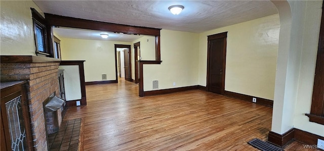 unfurnished living room featuring a textured ceiling and light hardwood / wood-style flooring