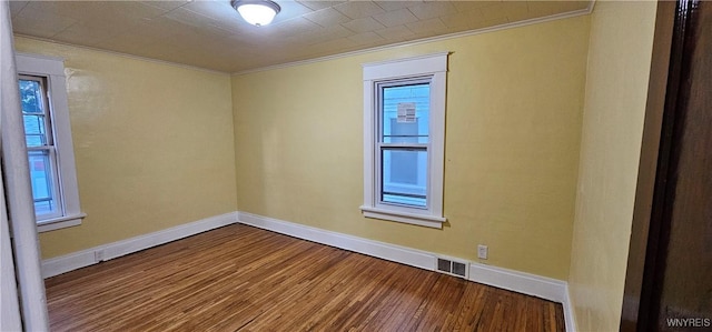 empty room featuring ornamental molding and hardwood / wood-style flooring