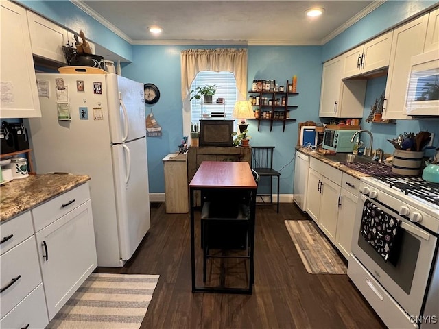 kitchen with white appliances, white cabinetry, dark stone counters, dark hardwood / wood-style floors, and crown molding