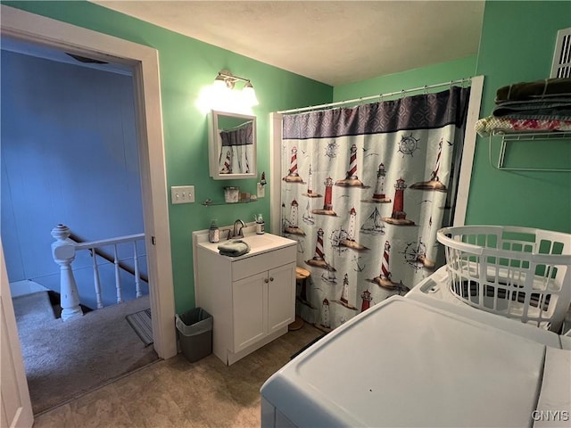 bathroom featuring washer / dryer, a shower with shower curtain, water heater, and vanity