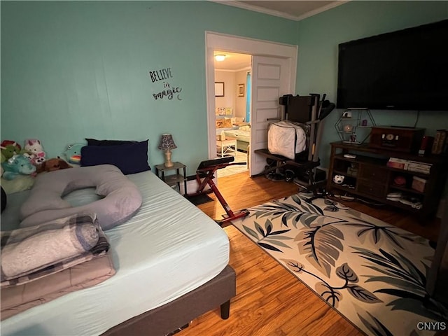 bedroom with hardwood / wood-style flooring and ornamental molding