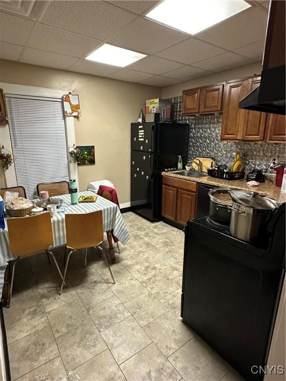 kitchen featuring extractor fan, tasteful backsplash, electric stove, sink, and a drop ceiling