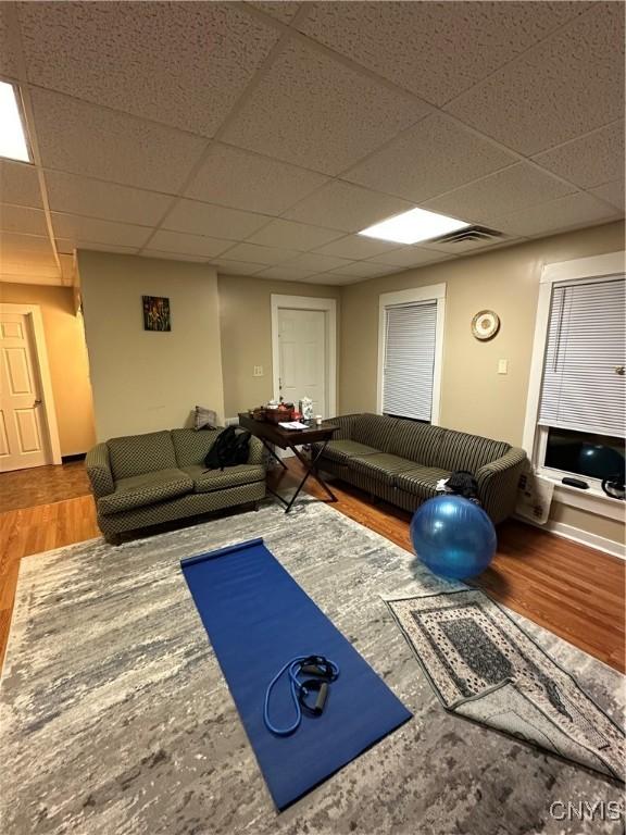 exercise area with a drop ceiling and wood-type flooring