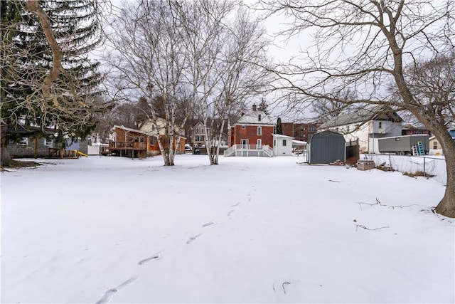 yard covered in snow featuring a shed