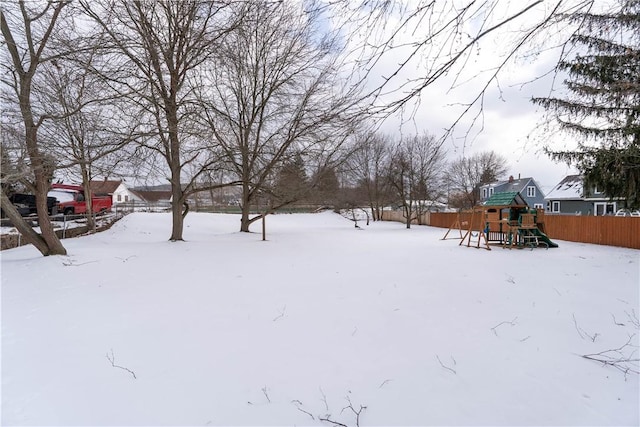 yard covered in snow featuring a playground