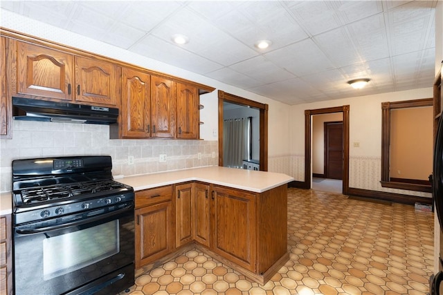 kitchen featuring a paneled ceiling, backsplash, kitchen peninsula, and black range with gas cooktop