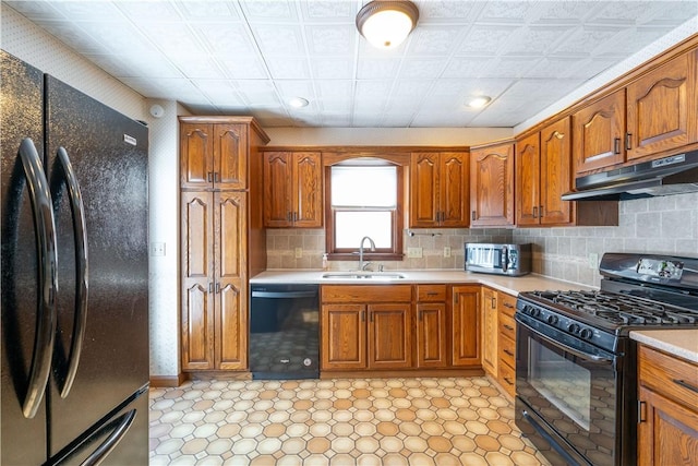 kitchen featuring decorative backsplash, sink, and black appliances