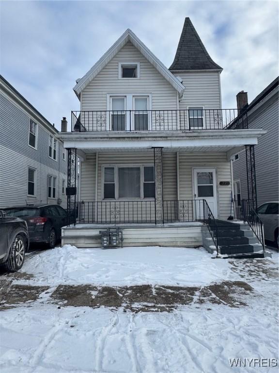 view of front of property featuring a balcony and covered porch