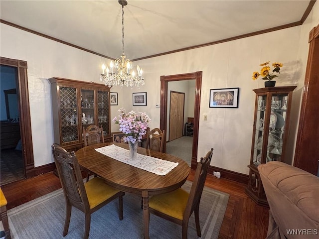 dining area featuring dark hardwood / wood-style flooring, a chandelier, and ornamental molding