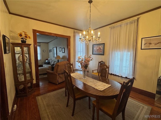 dining area featuring ornamental molding, hardwood / wood-style flooring, and a notable chandelier