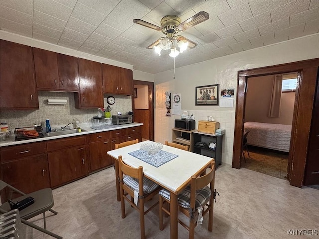 kitchen with ceiling fan, dark brown cabinets, and sink