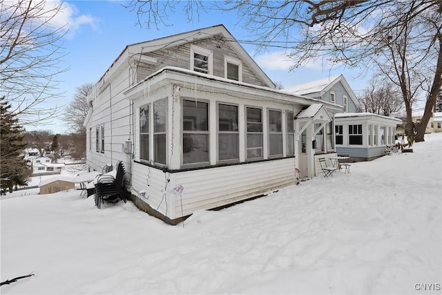 view of snow covered exterior with a sunroom