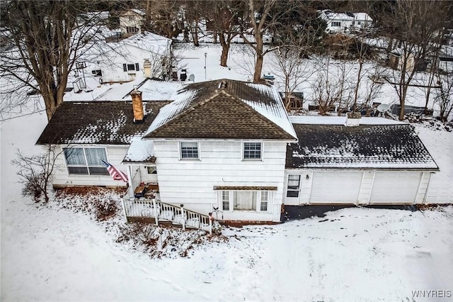 snow covered property with a garage