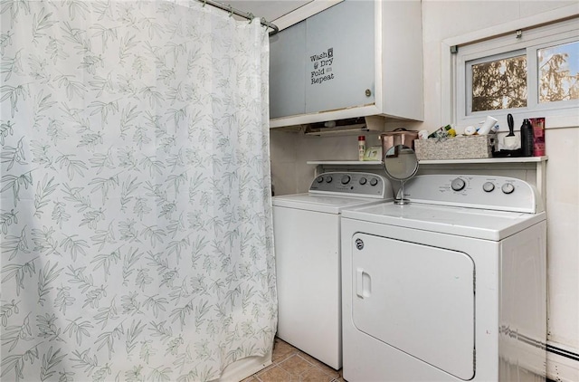 laundry room featuring cabinets, light tile patterned floors, and washing machine and dryer