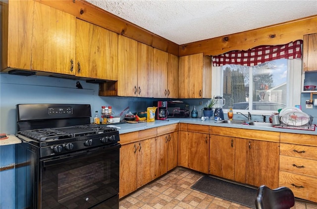 kitchen featuring a textured ceiling, sink, and black range with gas cooktop