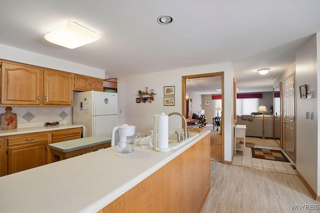 kitchen featuring backsplash, white fridge, and light hardwood / wood-style flooring