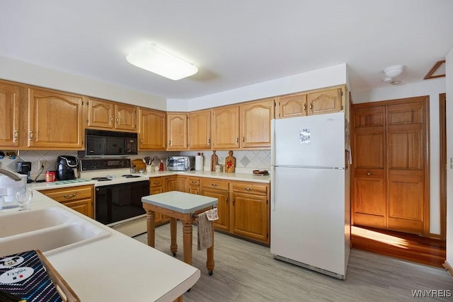 kitchen featuring electric range, white refrigerator, light hardwood / wood-style flooring, and tasteful backsplash