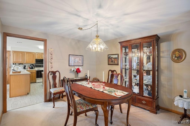 carpeted dining space with an inviting chandelier and sink