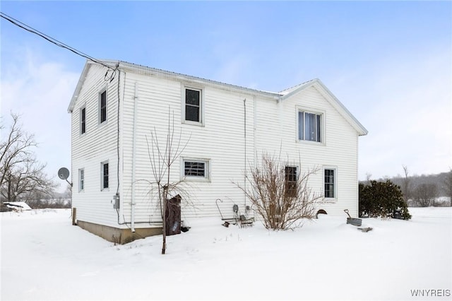 view of snow covered rear of property