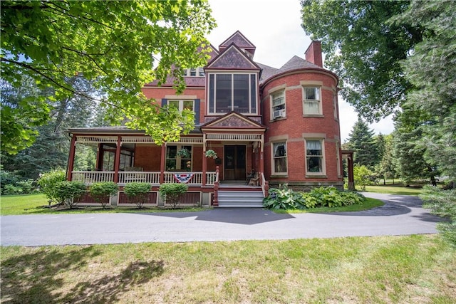 victorian home with a front lawn and a porch