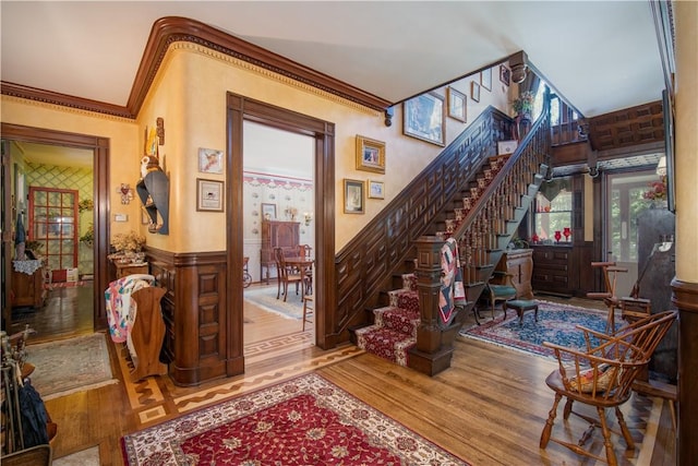 stairs featuring wood-type flooring and ornamental molding