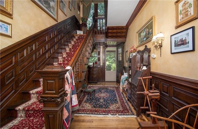 foyer with ornamental molding and hardwood / wood-style floors