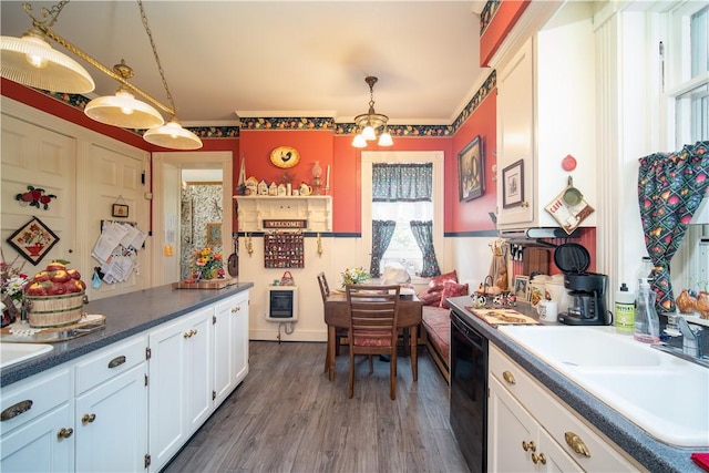 kitchen featuring white cabinetry, black dishwasher, dark hardwood / wood-style flooring, hanging light fixtures, and sink