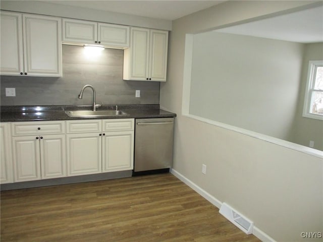 kitchen with white cabinetry, dark hardwood / wood-style floors, tasteful backsplash, dishwasher, and sink